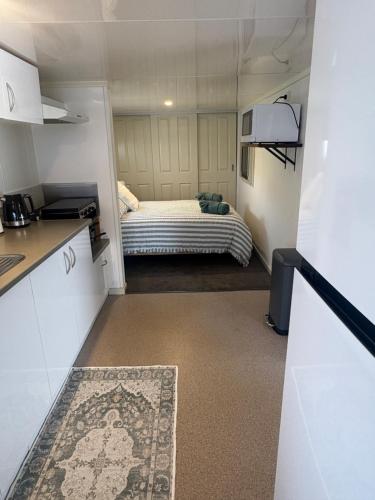 a small room with a bed and a kitchen at Turners Beach Holiday Cabin in Turners Beach