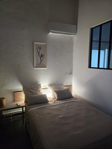 a bedroom with a large bed with a window at Charmant logement in Lamentin