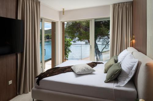 a bedroom with a bed and a large window at Luxury villa Zara, first row to the sea! in Kali