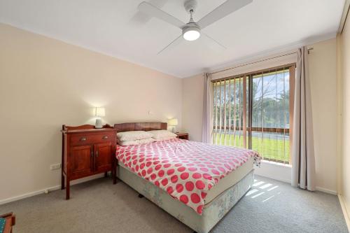a bedroom with a bed and a large window at Pet Friendly in Port Elliot in Port Elliot