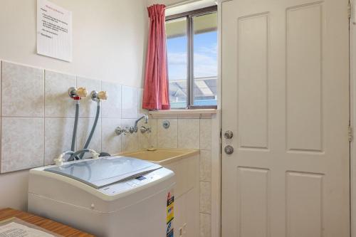 a small bathroom with a toilet and a window at Pet Friendly in Port Elliot in Port Elliot