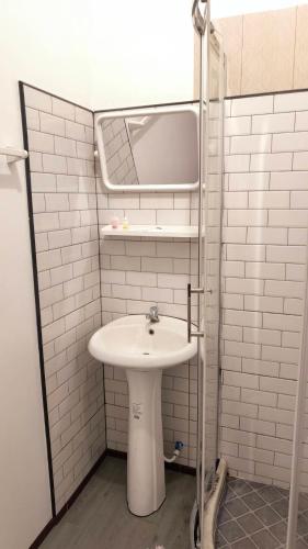 a white bathroom with a sink and a mirror at Saengcha Farm Resort in Prachin Buri