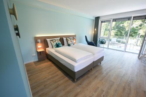 a bedroom with a bed and a large window at Steverbett Hotel in Lüdinghausen