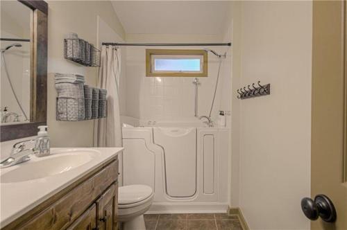 a bathroom with a shower and a toilet and a sink at The American Carriage House in Liberty