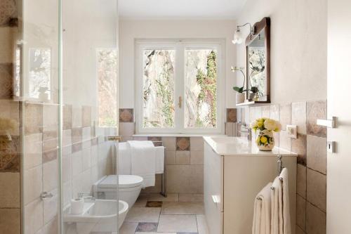 a bathroom with a toilet and a sink and a window at Villa Melody by Aura Luxury Collection in Molino Nuovo