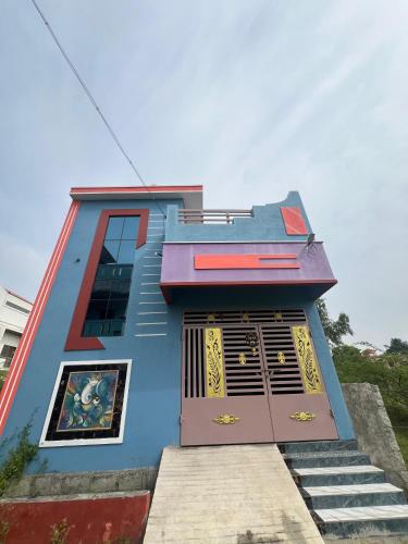 a blue building with a door and stairs in front at Love Home stay in Dharmpura