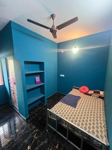 a blue room with a bed and a ceiling fan at Love Home stay in Dharmpura