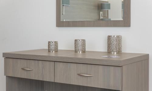 a wooden dresser with two cups on top of it at The Lion & Key Hotel in London