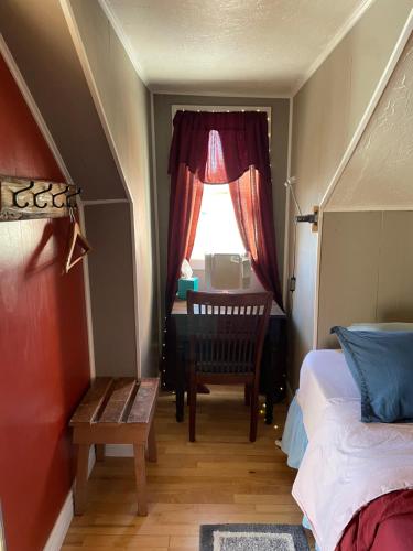 een slaapkamer met een bed, een bureau en een raam bij The Desert Farm in Escalante