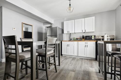 a kitchen with white cabinets and a table and chairs at 4BR Niagara Falls Home Free Parking WiFi in Niagara Falls