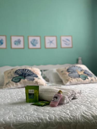a white bed with a towel and a bottle on it at Suíte Maresia - Pousada Castelo do Luar in Penha