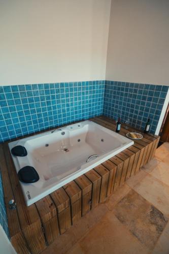 a bath tub in a bathroom with blue tiles at Hotel Via Do Sol Eco Chalés in Trairi
