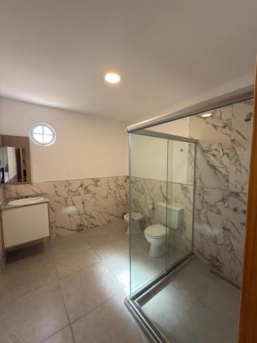 a bathroom with a glass shower and a toilet at Hotel Playas De Oro in Villa Carlos Paz