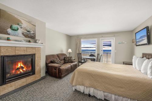a hotel room with a bed and a fireplace at Ground Floor Fireplace Studio - Ocean View & Beach Access - Pool and Hot Tub in Lincoln City