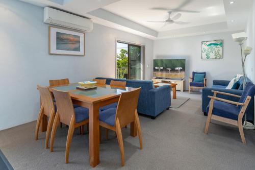a living room with a table and chairs and a couch at Sandcastle 7 with WiFi in Tuncurry