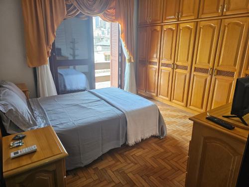 a bedroom with a bed and a large window at Casa de veraneio 2 dormitórios in Torres