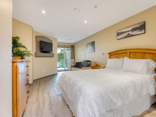 a bedroom with a large bed and a television at Oceanside Getaway in Nanoose Bay