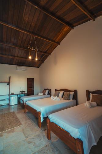 a room with two beds and a television in it at Hotel Via Do Sol Eco Chalés in Trairi