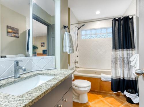 a bathroom with a sink and a toilet and a tub at Oceanside Getaway in Nanoose Bay