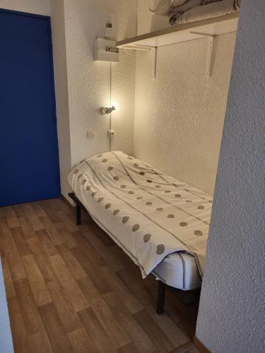 a bed in a room with a blue wall at Studio meublé centre ville Paray A4 in Paray-le-Monial