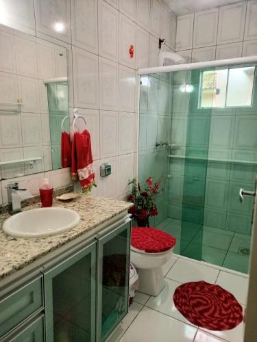 a bathroom with a shower and a toilet and a sink at Casa temporada perto do centro in Garopaba