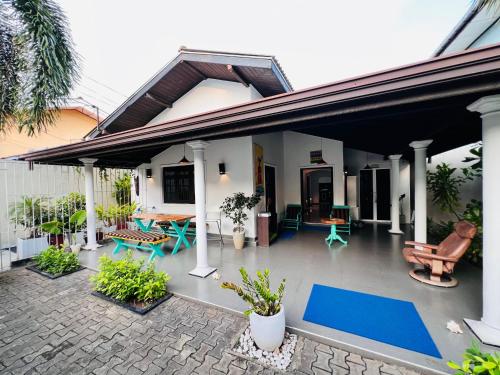 a house with a patio with a blue mat at Villa Kyda - 2 Min walk to the Beaches! in Tangalle