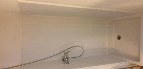 a white shower with a faucet in a bathroom at Studio meublé centre ville Paray A4 in Paray-le-Monial