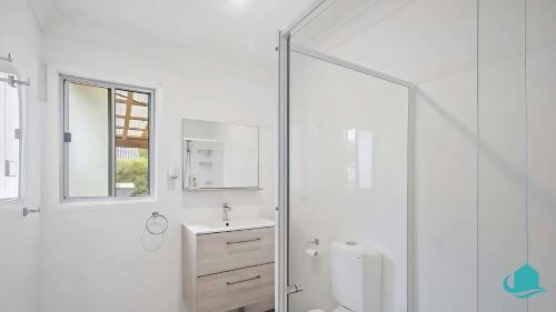 a white bathroom with a sink and a shower at Casa Bella in Lakeside