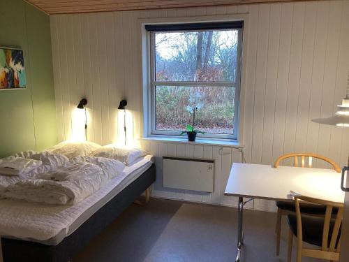 Holiday home for 2 guests, Ansager في Ansager: غرفة نوم بها سرير وطاولة ونافذة
