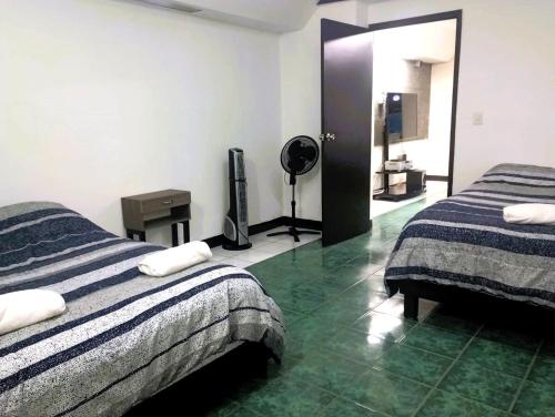 een hotelkamer met twee bedden en een televisie bij Departamentos Arista in Oaxaca City