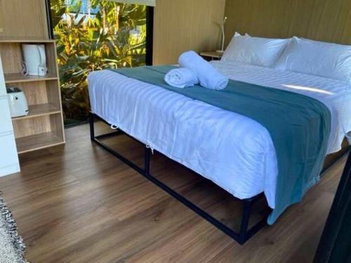a large bed with two pillows on top of it at The Stables by Tiny Away in Palmwoods
