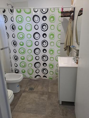 a bathroom with a green and white shower curtain at Casa de Andres in Ataliva Roca