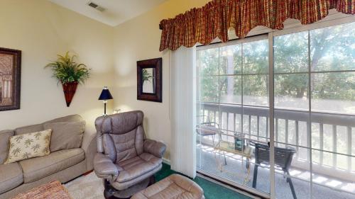 Royal Poste Unit 2605 في صن سيت بيتش: غرفة معيشة بها أريكة وكرسي ونوافذ كبيرة