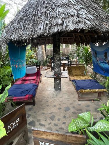 Kwa Nzeu في شاطئ دياني: مجموعة من الأسرة تحت مظلة من القش