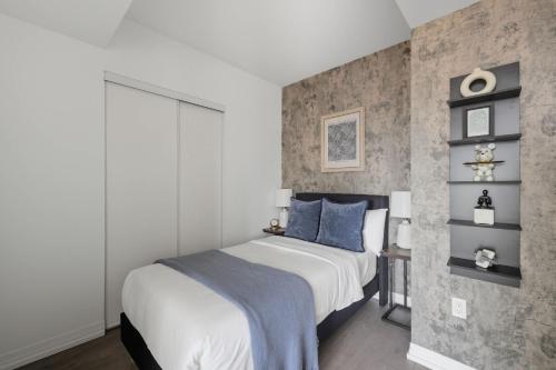 a bedroom with a large bed with blue pillows at Toronto Skyline Stay Modern Design & View in Toronto