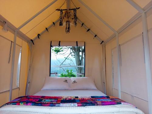 a bed in a room with a window at Cabaña tipi Ardilla Silvania Cundinamarca in Silvania