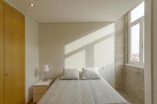 a bedroom with a large bed and a window at Bright Luxury Apartment in Viana do Castelo