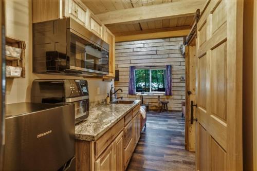 a kitchen with wooden cabinets and a counter top at Riverfront, Authentic, Luxury Log Cabin-Black Bear in Wasilla