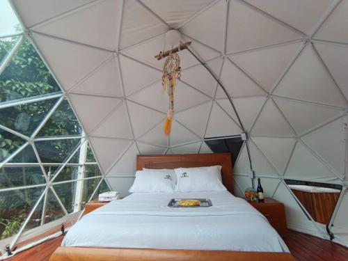 Glamping Morpho Azul Silvania Cundinamarca في سيلفانيا: غرفة بسرير في خيمة القبة