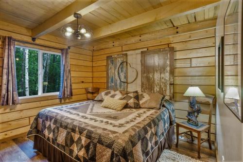 a bedroom with a bed in a log cabin at Riverfront, Authentic, Luxury Log Cabin-Black Bear in Wasilla