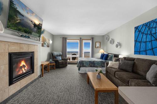 a living room with a couch and a fireplace at Top Floor Ocean View Suite - Sleeps Six - Pool & Hot Tub Access in Lincoln City
