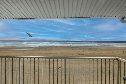 a bird flying over a beach with the ocean at Top Floor Ocean View Suite - Sleeps Six - Pool & Hot Tub Access in Lincoln City