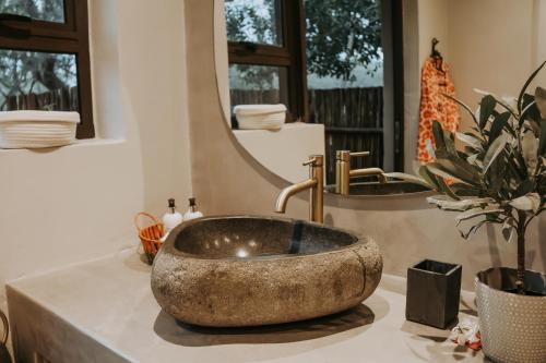 a bathroom with a stone sink and a mirror at Wildlife Estate Villa - Pool - Boma - Bushlife in Hoedspruit