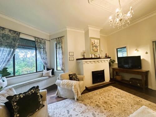 Hilltop Cottage في بريدج تاون: غرفة معيشة فيها موقد وثريا