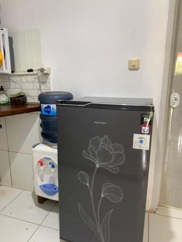 a refrigerator with a flower painted on it in a kitchen at Nova Homestay in Kuta Lombok