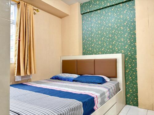 雅加达Cozy 2BR Kalibata City的卧室里有一张铺着蓝白床单的床