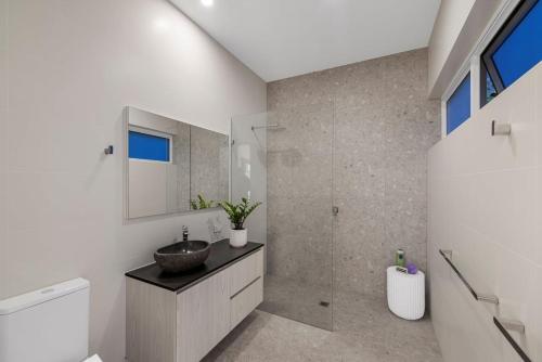 15 Scrub Rd - A Modern Coastal Luxury Retreat في كولوم بيتش: حمام مزود بحوض ومِرآة