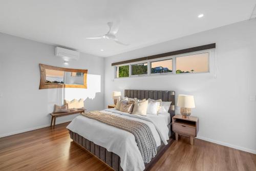 15 Scrub Rd - A Modern Coastal Luxury Retreat في كولوم بيتش: غرفة نوم بيضاء مع سرير ونافذتين