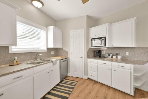 una cucina bianca con mobili bianchi e un lavello di Waterfront One Of A Kind Lighthouse with Large Dock a Livingston