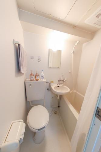 a white bathroom with a toilet and a sink at ハイクレスト中野203 in Tokyo